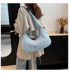 Vue latérale du sac à bandoulière en nylon matelassé bleu clair avec sangle réglable