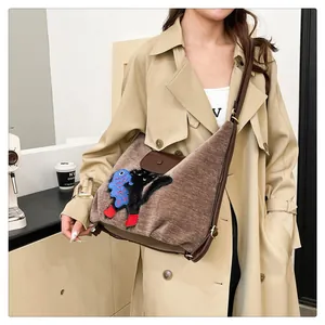 Détail du sac cabas en velours côtelé marron avec broderie chat et bandoulière en cuir