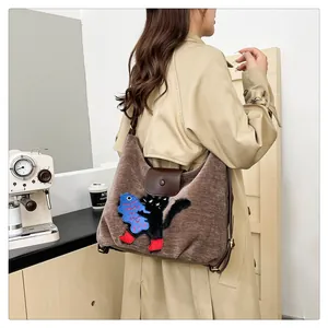 Détail d'un sac cabas marron avec broderie chat noir et rabat en cuir élégant