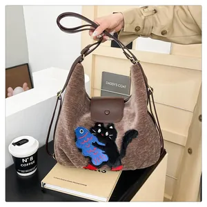 Détail du sac cabas en daim marron vintage avec motif de chat brodé et bandoulière en cuir