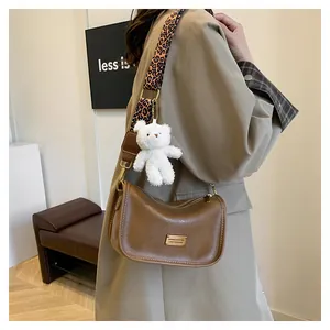 Brown retro Boston bag featuring a leopard print strap and cute plush bear charm detail