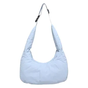 Quilted light blue crescent tote bag with adjustable strap and padded texture for women