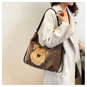 Sac hobo en velours côtelé marron avec applique chiot en peluche porté par un mannequin
