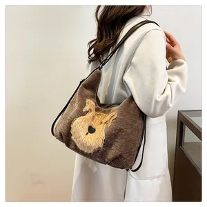 Détail du sac cabas en velours côtelé marron avec écusson chien en peluche 3D