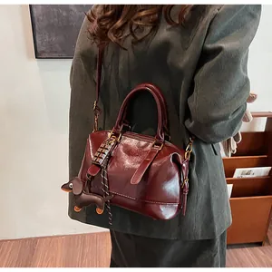 Close-up of vintage burgundy boston bag with chocolate and dachshund pendants