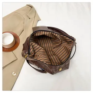Détail de l'intérieur du sac vintage avec doublure rayée et fermeture magnétique