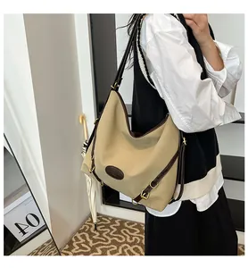 Detail of khaki canvas tote with brown leather strap and vintage gold metal hardware