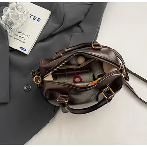 Interior view of brown Boston bag showing capacity for umbrella, wallet and cosmetics