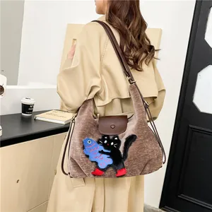 Sac fourre-tout rétro marron avec broderie chat, présenté sur un mannequin de mode