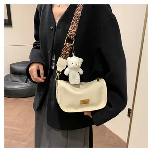 Chic beige Boston bag with leopard print strap and plush bear charm shown on model