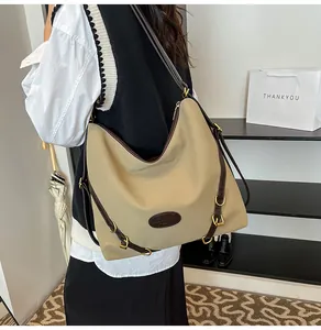 Lifestyle view of large khaki tote bag with brown leather straps and metal buckles