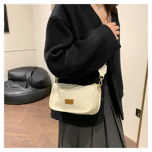Detail of off-white PU leather bag with gold metal plate and leopard print strap