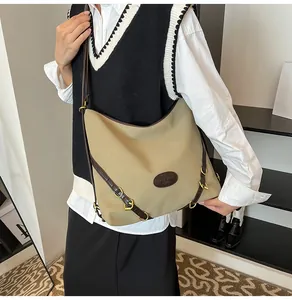 Detail of khaki tote bag showing leather trim, metallic buckles and adjustable shoulder straps