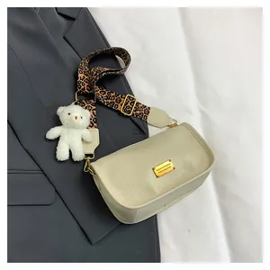 Cream Boston bag detail featuring leopard print strap and cute plush bear charm accessory