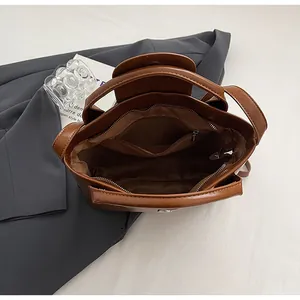 Bovenaanzicht van de bruine lederen handtas met ritsvak en magnetische sluiting