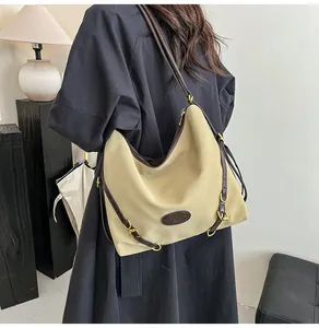 Detailed view of large tote bag with brown leather straps and elegant metal hardware