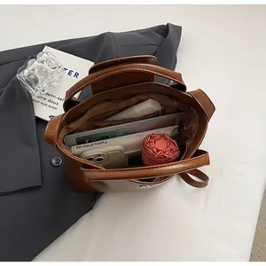 Binnenaanzicht van de bruine tote bag met grote capaciteit, ritsvak en diverse vakken