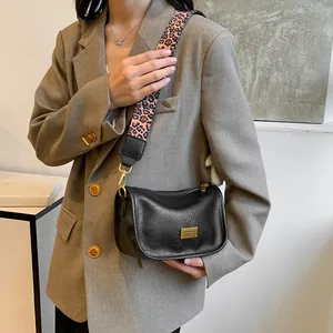 Classic black Boston bag in lychee leather with a trendy pink leopard patterned strap