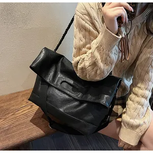 Détail du grand sac cabas en cuir souple noir avec bandoulière épaisse en toile