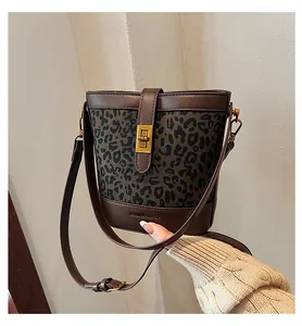 Détail du sac seau léopard avec fermoir tournant doré et logo de marque gravé