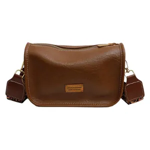 Brown litchi leather Boston crossbody bag with a stylish leopard print wide strap