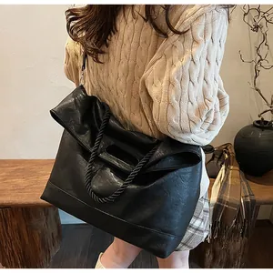 Détail du sac cabas noir avec poignées en corde torsadée et texture mate au toucher doux