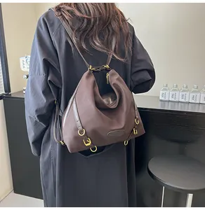 Brown pleated tote bag shown on back, featuring high-capacity design and gold hardware