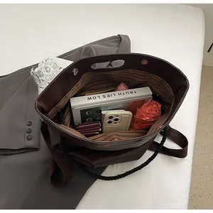 Détail intérieur du grand sac cabas marron avec doublure rayée et grande capacité