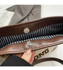 Detail of the tote bag showing blue striped lining and metallic magnetic snap closure