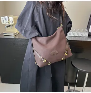 Detail of a large coffee-colored vintage tote bag with gold metal buckle accents