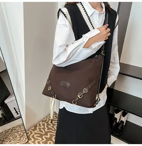 Detail of vintage pleated tote bag with dark brown leather straps and brass D-rings
