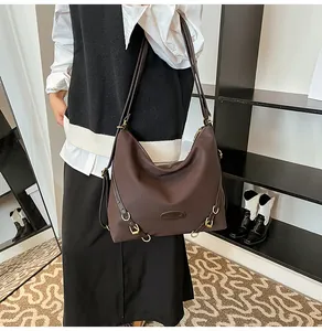 Detailed view of coffee tote bag with decorative metal rings and pleated design