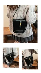Détail d'un sac seau noir avec boucle dorée et texture en cuir lisse élégante