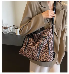 Detalle del bolso de leopardo con cremallera metálica y cordón ajustable negro