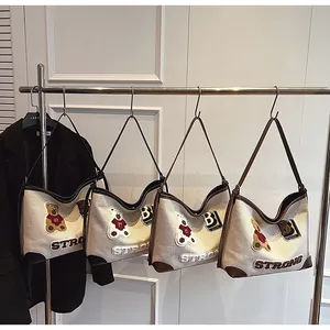 Detail of high-quality canvas tote bags with teddy bear patches and faux leather straps