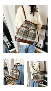 Detail of plaid wool tote bag with brown leather trim and metal buckle on strap