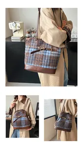 Close-up of vintage tartan plaid tote bag with brown leather trim and metal buckle detail