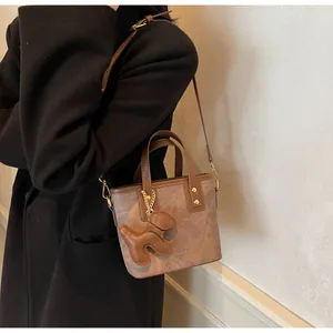 Braune Retro-Beuteltasche mit Hundeanhänger als Umhängetasche auf schwarzem Wollmantel