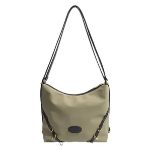 Modern khaki pleated tote bag with black double straps and leather patch on white background