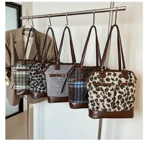 Detail of five vintage tote bags with leopard print and plaid textures on a rack