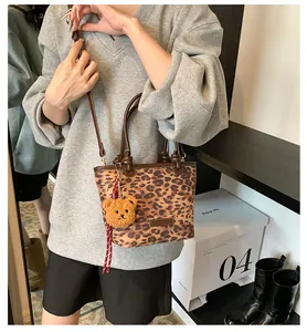 Dettaglio della borsa a secchiello leopardata con ciondolo a orsetto e tracolla