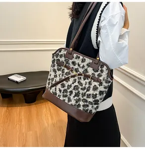Detail of vintage leopard print tote bag with brown leather straps shown on a model