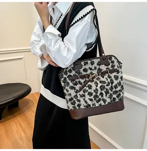 Close-up of leopard print faux fur tote bag with brown leather shoulder straps and details