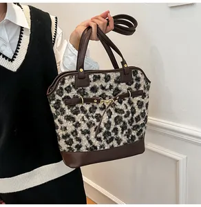 Macro view of leopard print tote with sequins, dark leather trim and gold hardware