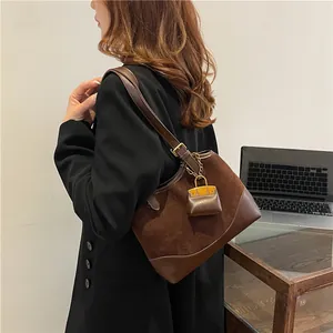 Brown suede bucket bag with leather strap and golden hardware for 2025 casual fashion
