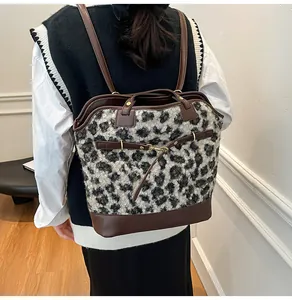Detail of leopard print faux fur backpack with dark brown leather straps and metal buckle