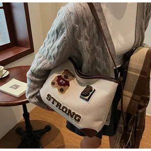 Detail of vintage canvas tote with bear embroidery and dark brown leather trimming