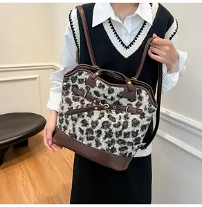 Detailed close-up of leopard print tote bag with brown leather base and adjustable straps