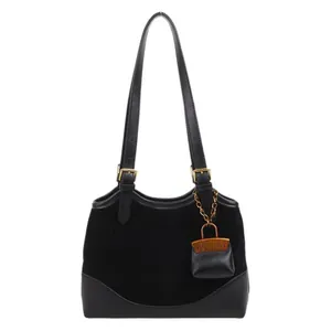 Black winter bucket bag in matte suede and leather with a mini charm pendant