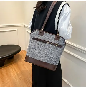 Detail of grey tweed tote bag with dark brown leather straps and vintage gold buckle decoration